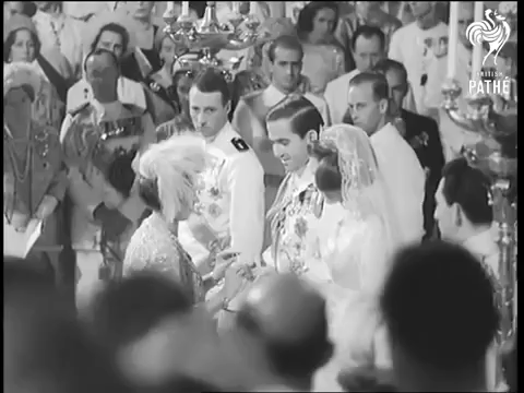 Queen Friederike puts wedding rings on the couple's fingers