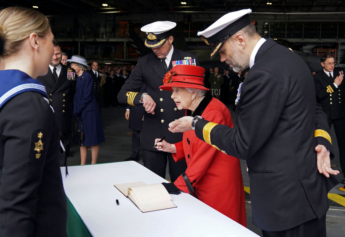 Queen Elizabeth II reacts as she meets military personnel during her visit to the aircraft carrier HMS Queen Elizabeth in Portsmouth, southern England on May 22, 2021