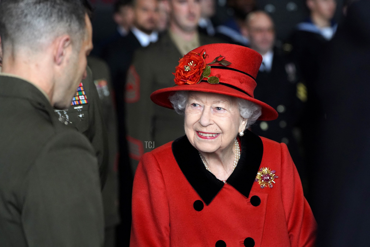 Queen Elizabeth II reacts as she meets military personnel during her visit to the aircraft carrier HMS Queen Elizabeth in Portsmouth, southern England on May 22, 2021