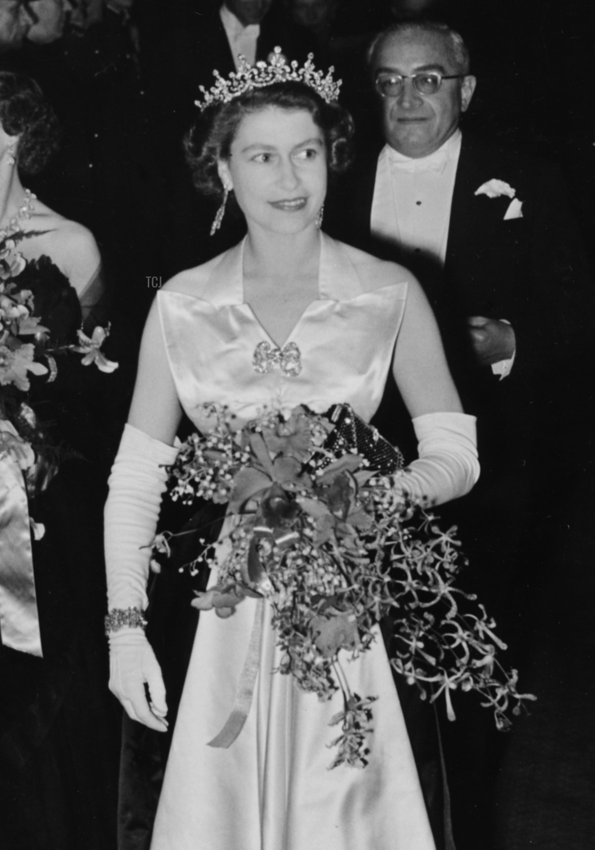 Queen Elizabeth II is escorted by Reginald Bromhead, the Chairman of the Cinematograph and Trade Benevolent Fund, as she and Princess Margaret (behind) leave the Royal Film Performance in Leicester Square, London, October 27th 1952