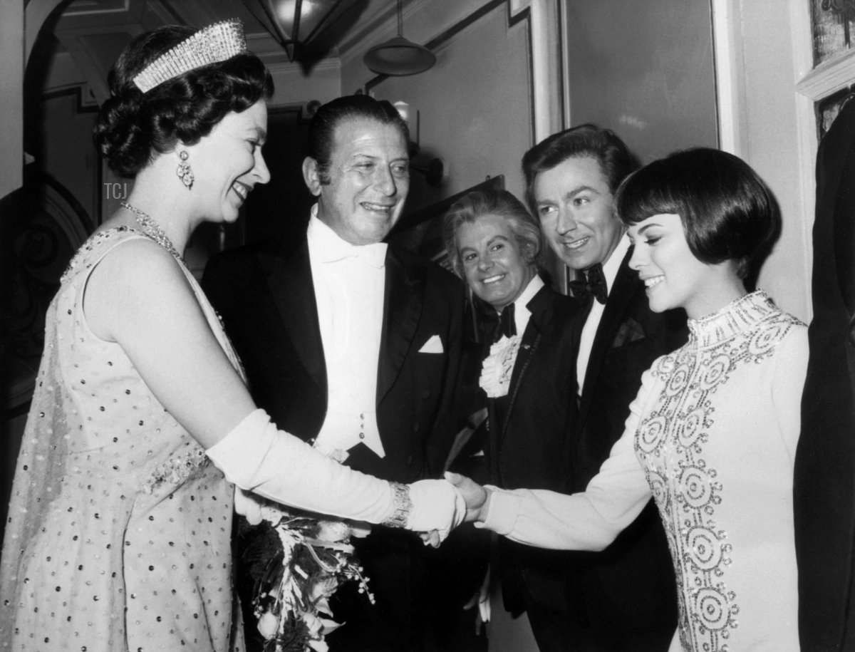 Britain's Queen Elizabeth II (L) shakes hands with French singer Mireille Mathieu in 1969 in London after the French artist performance