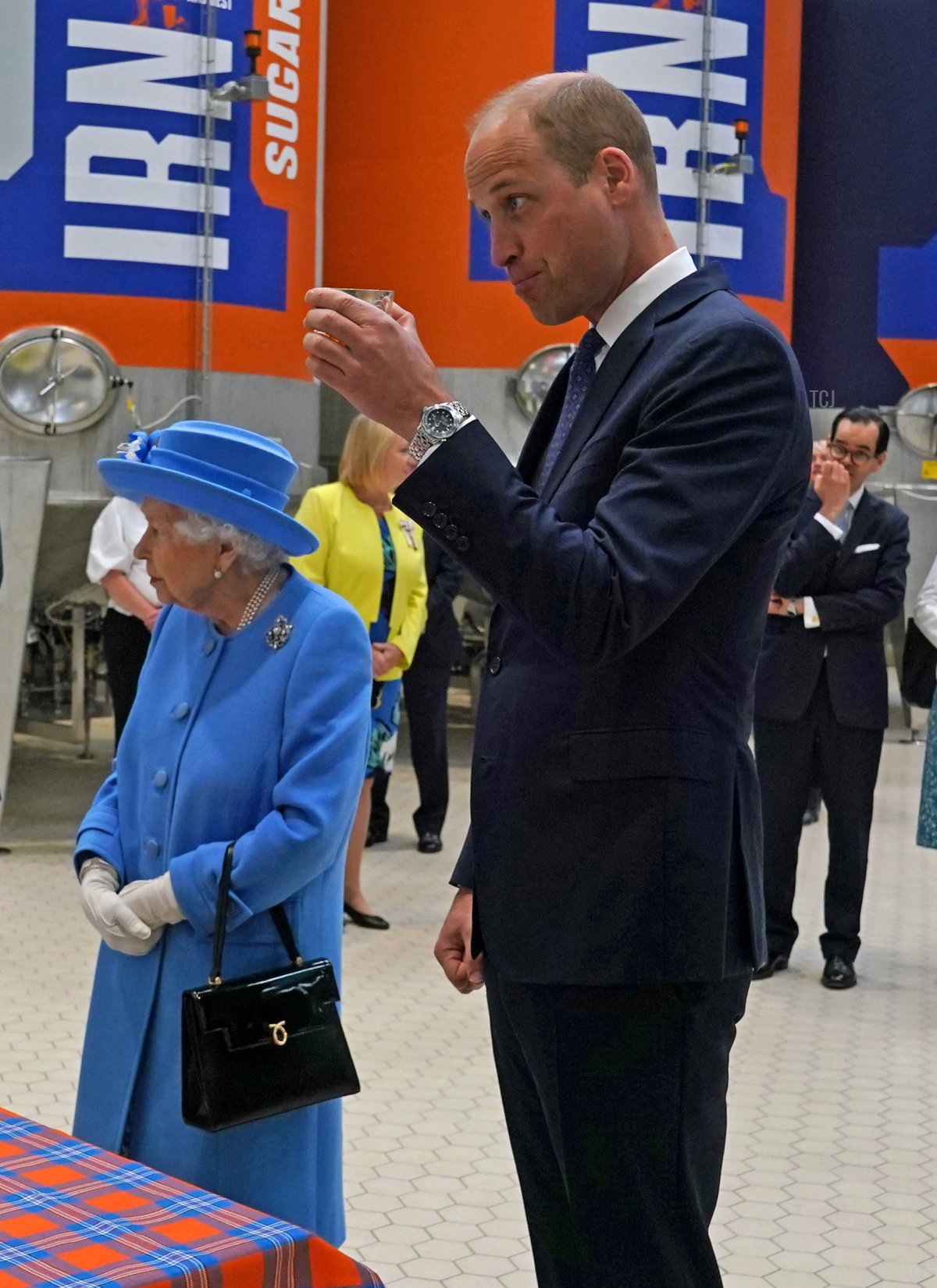 Britain's Prince William, Duke of Cambridge (R) reacts while sampling Irn-Bru as he and Britain's Queen Elizabeth II visit AG Barr's factory in Cumbernauld, east of Glasgow, where the Irn-Bru drink is manufactured on June 28, 2021