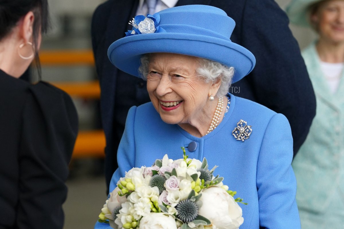 Britain's Queen Elizabeth II receives flowers as she meets employees during a visit to AG Barr's factory in Cumbernauld, east of Glasgow, where the Irn-Bru drink is manufactured on June 28, 2021