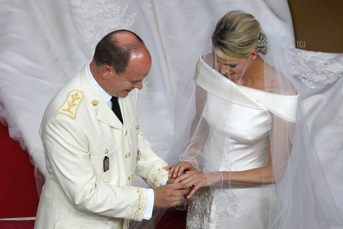 Prince Albert II of Monaco puts the ring on the finger of the left hand of Princess Charlene of Monaco at the altar during their religious wedding at the Main Courtyard of the Prince's Palace on July 2, 2011 in Monaco