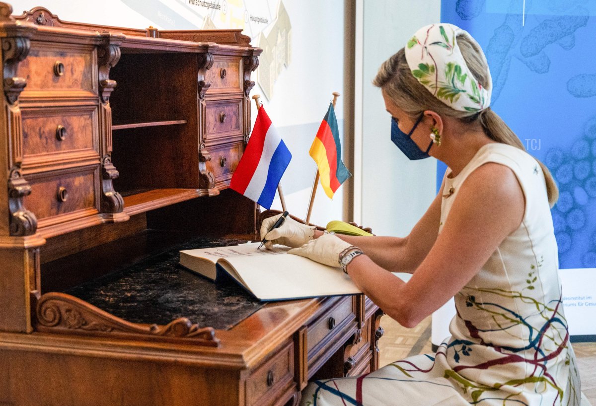 Queen Maxima of the Netherlands signs the Golden Book during a visit to the Robert-Koch-Institute (RKI, German national agency and research institute for disease control and prevention) on July 5, 2021 in Berlin