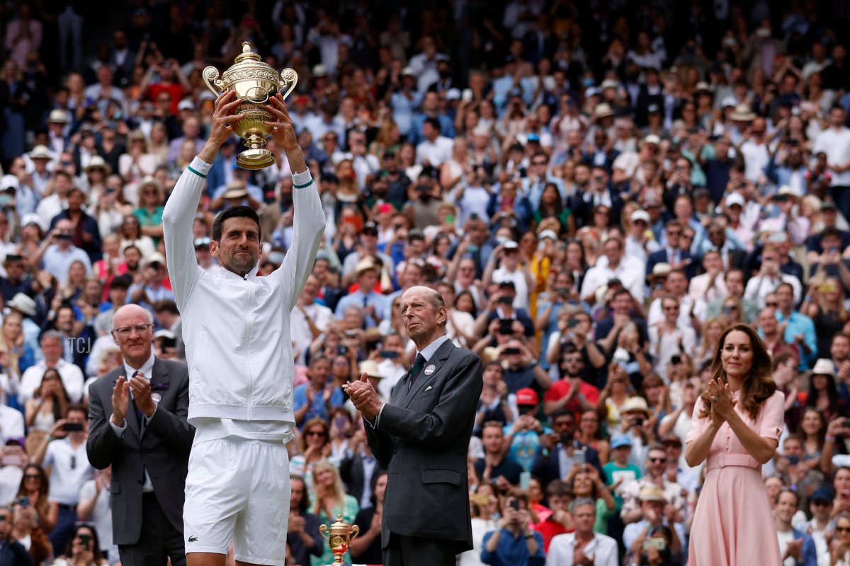 Serbia's Novak Djokovic, with Britain's Catherine (R), Duchess of Cambridge, holds the winner's trophy after beating Italy's Matteo Berrettini during their men's singles final match on the thirteenth day of the 2021 Wimbledon Championships at The All England Tennis Club in Wimbledon, southwest London, on July 11, 2021