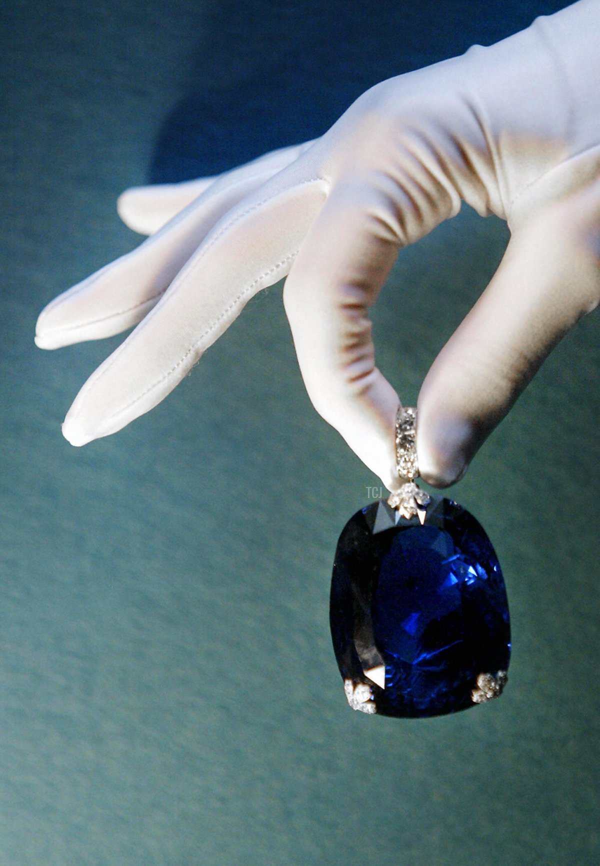 A woman holds a 478 carat sapphire which was previously owned by Queen Marie of Romania 08 October 2003 at Christie's in London