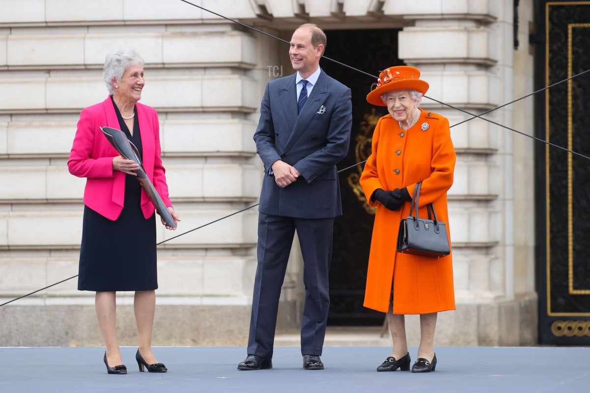 Queen Elizabeth II, Prince Edward, Earl of Wessex and Dame Louise Martin, President of the Commonwealth Games Federation speak on stage during the launch of The Queen's Baton Relay for Birmingham 2022, the XXII Commonwealth Games at Buckingham Palace on October 07, 2021 in London, England