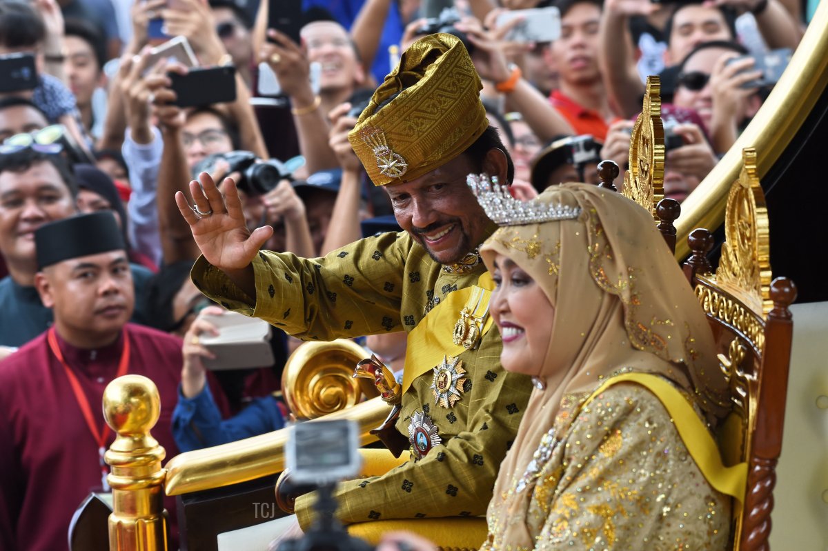 Brunei's Sultan Hassanal Bolkiah (center-L) and Queen Saleha (centre-R) wave from the royal chariot during a procession to mark his golden jubilee of accession to the throne in Bandar Seri Begawan on October 5, 2017