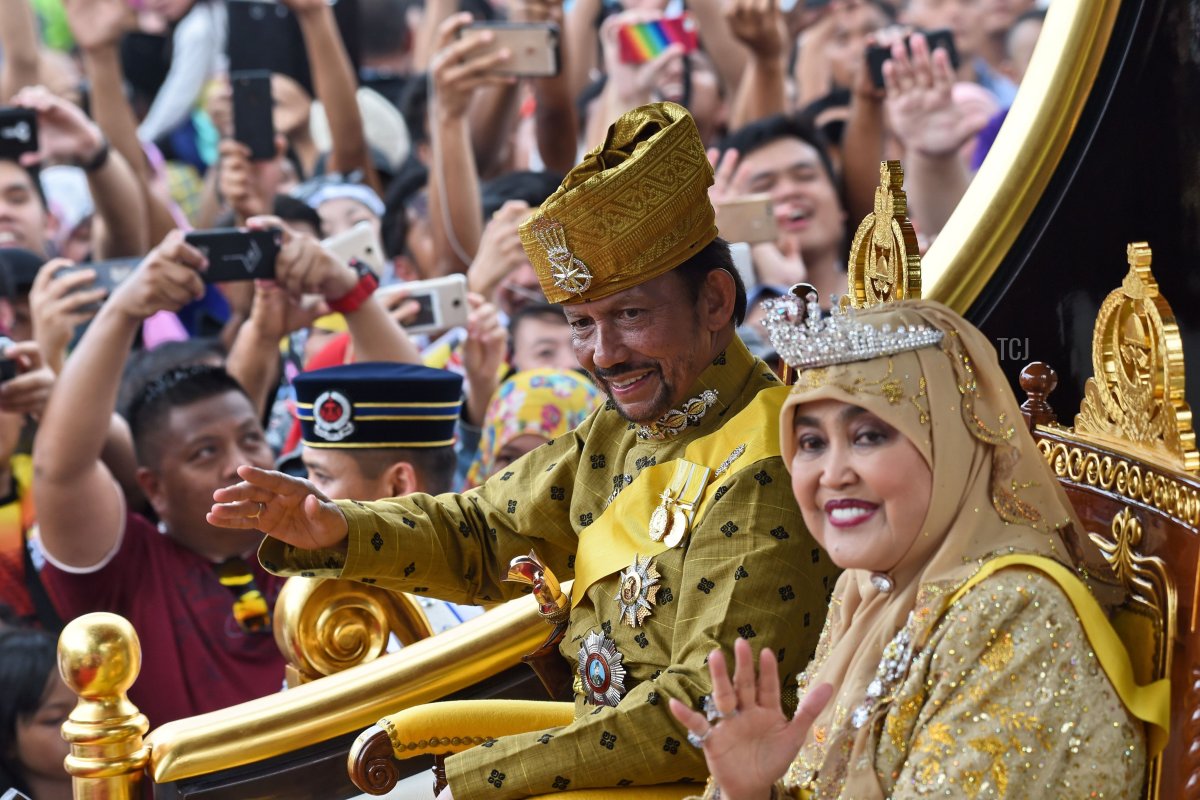 Brunei's Sultan Hassanal Bolkiah (center-L) and Queen Saleha (centre-R) wave from the royal chariot during a procession to mark his golden jubilee of accession to the throne in Bandar Seri Begawan on October 5, 2017