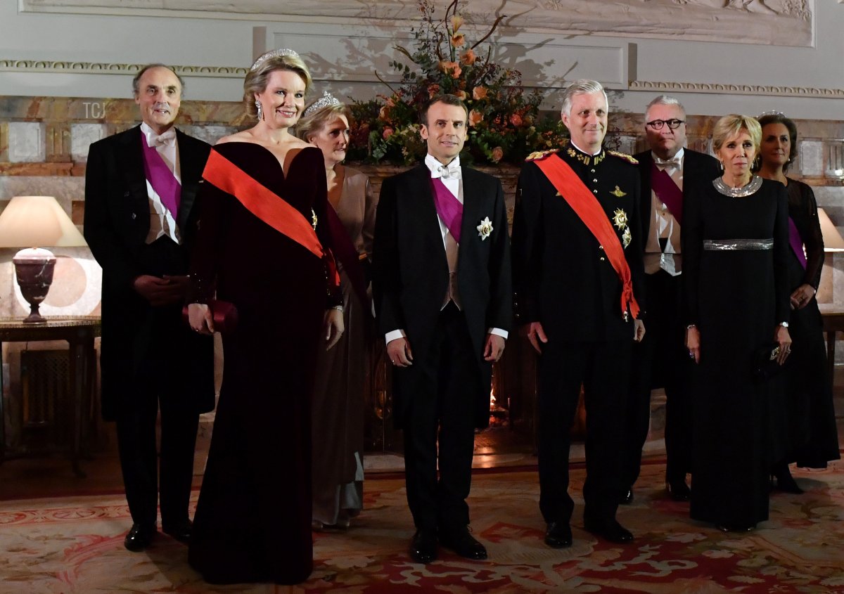 Belgium's royal couple Philippe of Belgium (2R) and Mathilde of Belgium (L), French President Emmanuel Macron (2L) and his wife Brigitte Macron (R) pose for photographers during a state dinner at the Royal Palace in Laeken, Belgium on November 19, 2018