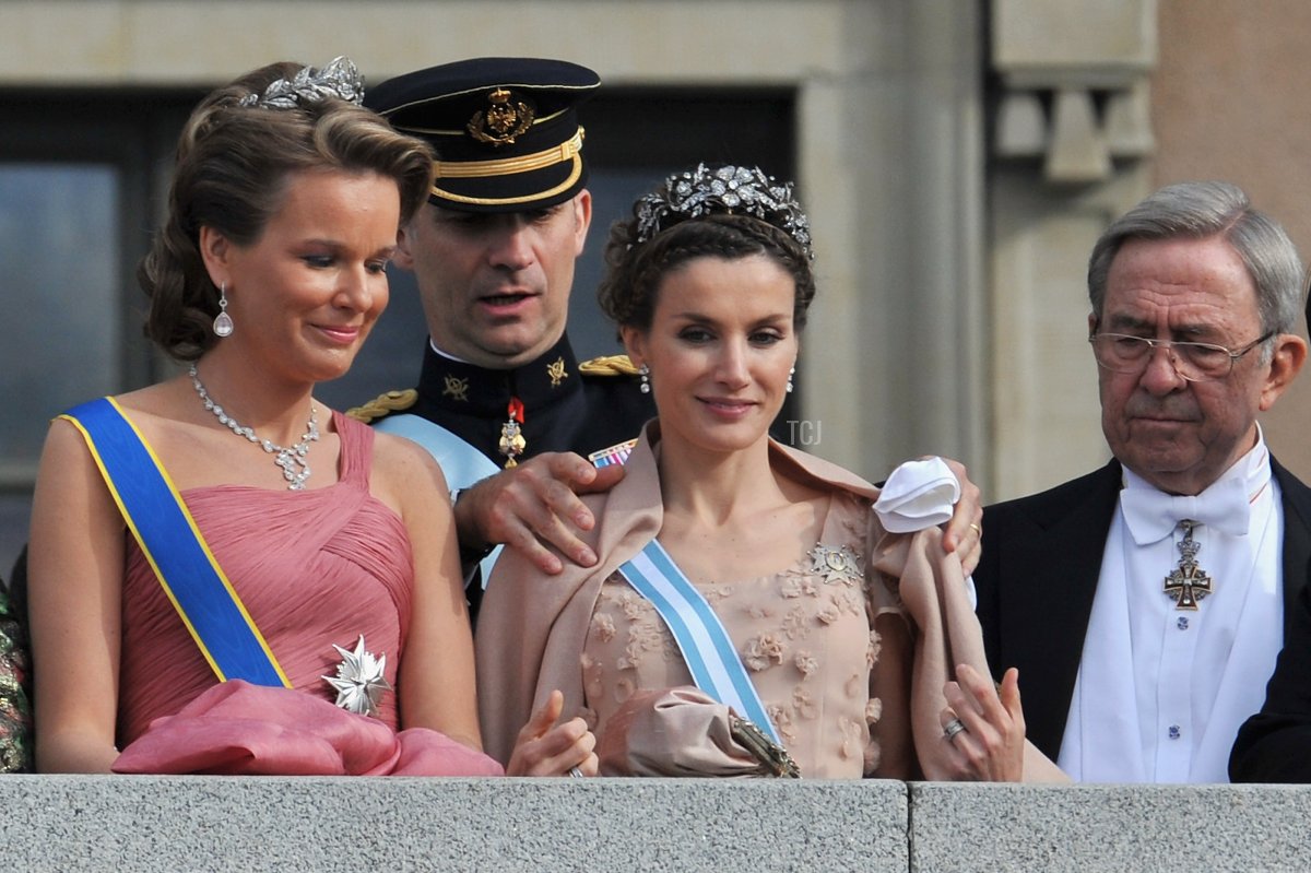 Crown Prince Felipe helps Crown Princess Letizia of Spain with her scarf as Crown Princess Mathilde of Belgium looks on as they appear on the Lejonbacken Terrace after Crown Princess Victoria and Prince Daniel of Sweden wedding ceremony on June 19, 2010 in Stockholm, Sweden