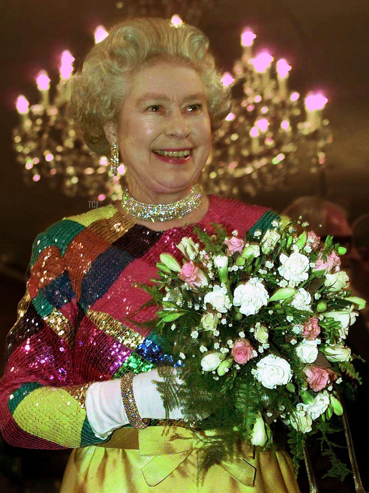 Britain's Queen Elizabeth wearing a brightly coloured harlequin dress arrives at Birmingham Hippodrome for the 1999 Royal Variety Performance