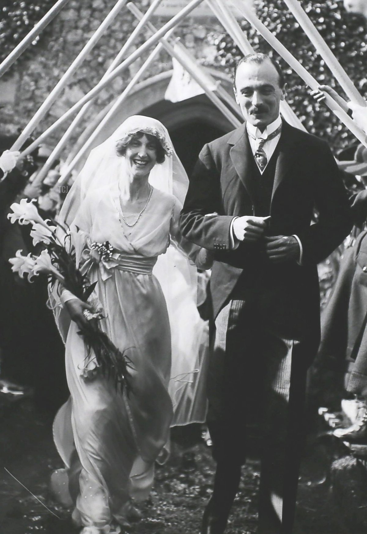 The bride and groom, Miss Phyllis Barclay and Captain H. Cecil Johnson leaving the church under an arch of Girl Scout staves after their wedding in Norwich, England, 16th April 1914