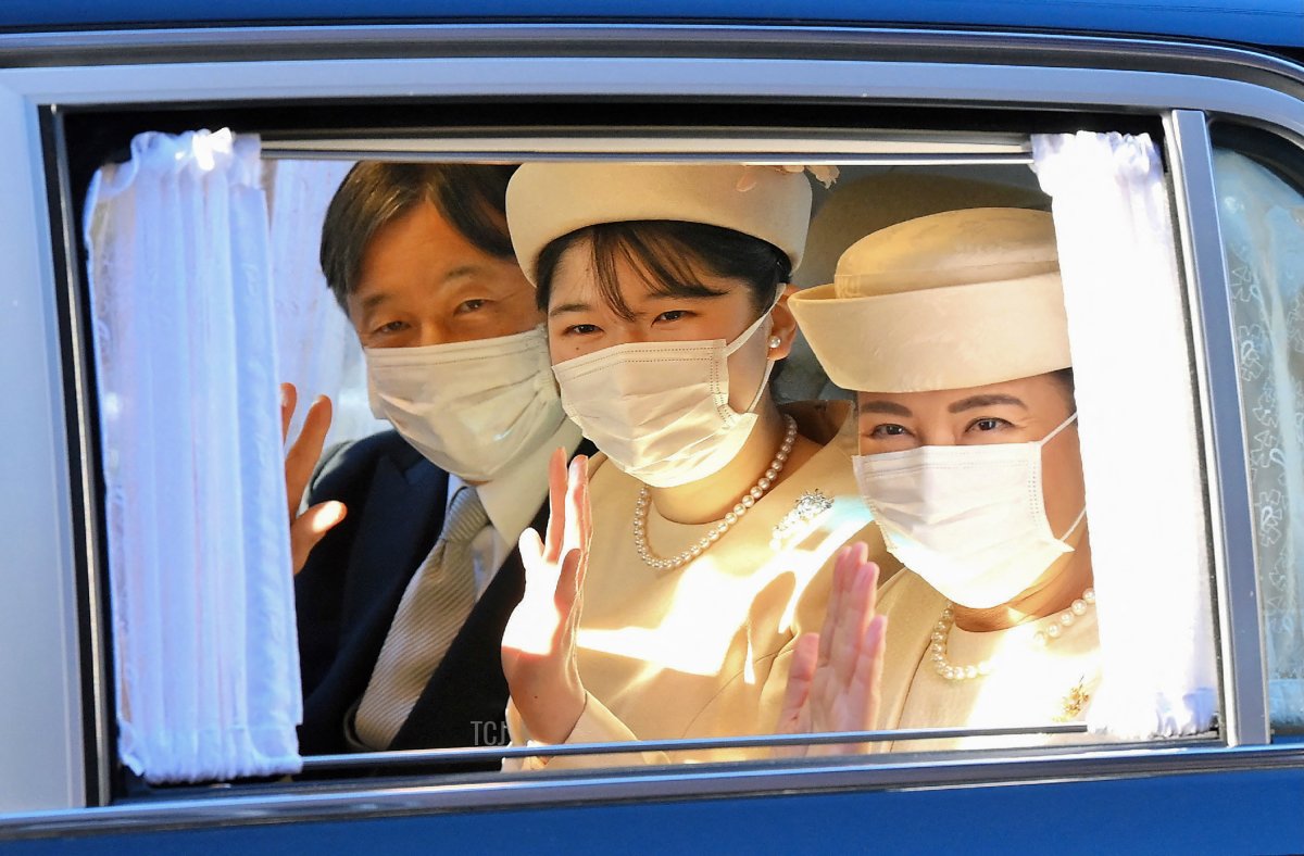 Japan's Emperor Naruhito (L), Empress Masako (R) and their daughter Princess Aiko (C) wave at members of the media from a car as they visit the former emperor and empress in Sento Karigosho, or "Temporary Emeritus Imperial Palace", in Tokyo on January 1, 2022