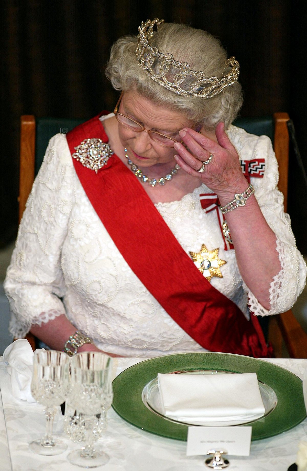 Queen Elizabeth II reacts when New Zealand Prime Minister Helen Clark offers her condolences for the recent death of her sister, Princess Margaret, during a state dinner at the Beehive in Wellington, 25 February 2002