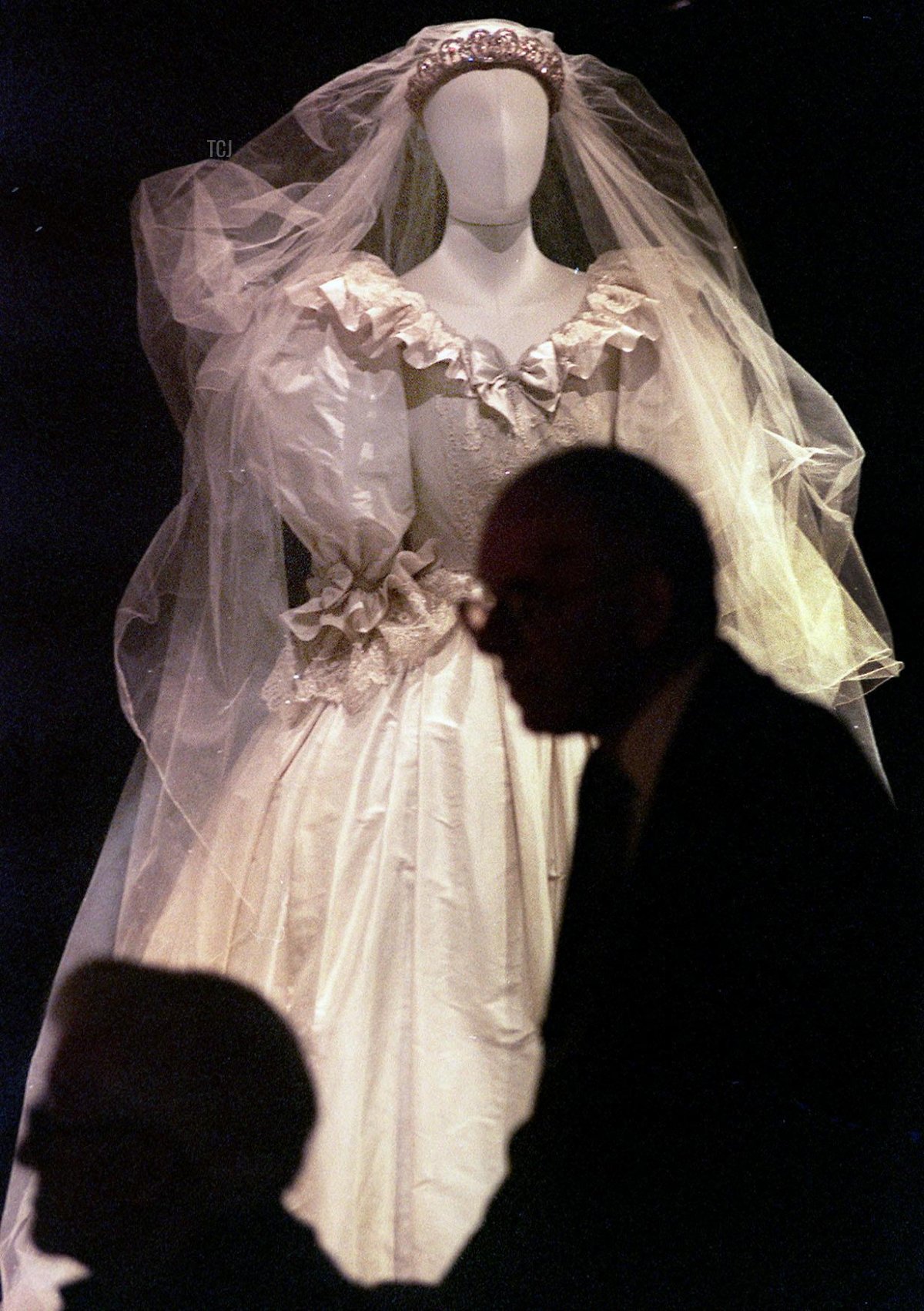 Visitors pass by the wedding dress worn by Diana, Princess of Wales 29 June 1999 on the opening day of the exhibition to celebrate her life at her ancestral home, Althop Park, also the site where she is buried