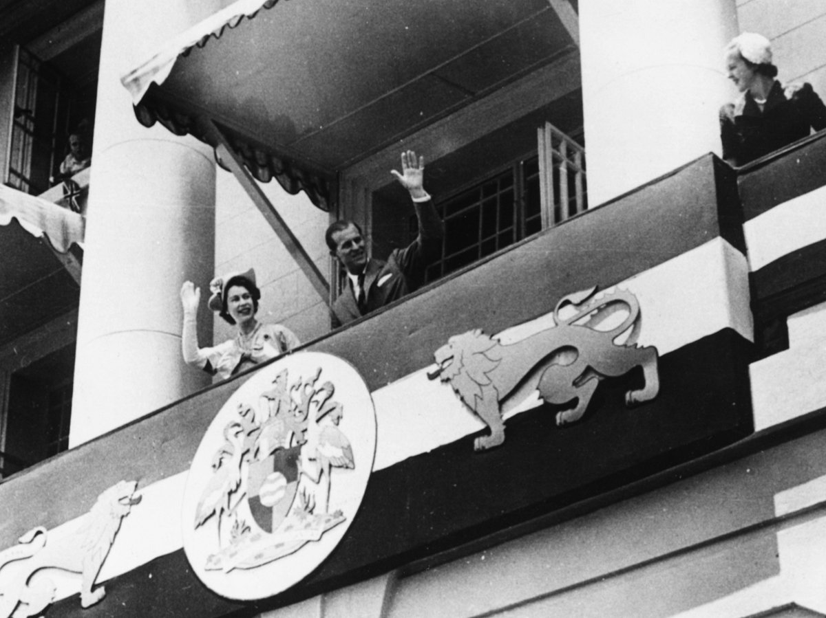 Princess Elizabeth (later Queen Elizabeth II) and Prince Philip, the Duke of Edinburgh, waving from the balcony of City Hall to the crowds below, during their Commonwealth tour, Nairobi, Kenya, 4th February 1952