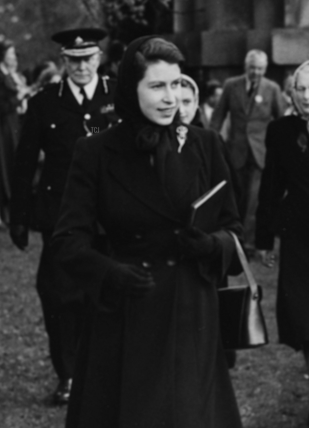 Queen Elizabeth II and the Duke of Beaufort walking past crowds of people as they make their way to watch the Olympic Horse Trials at Badminton, England, April 23rd 1952
