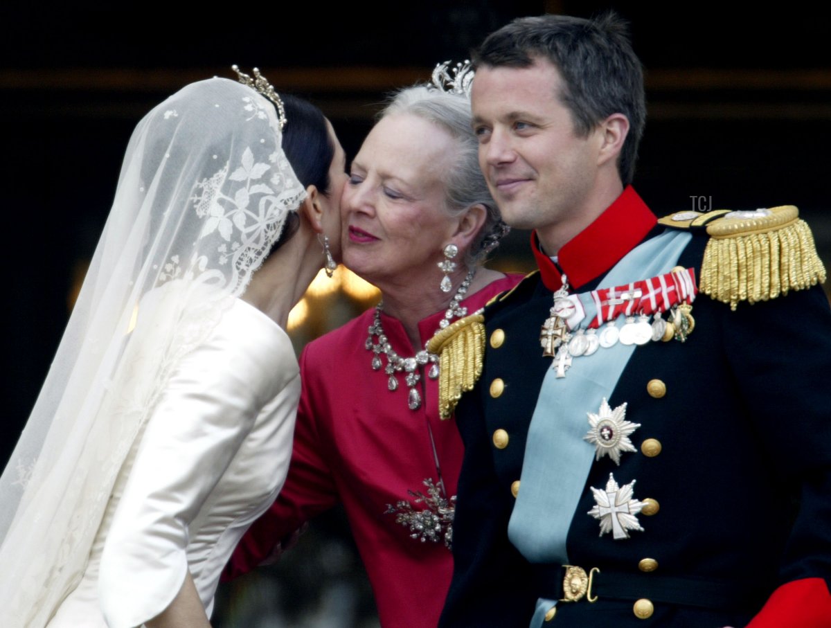 Crown Princess Mary kisses her mother-in-law Queen Margrethe II of Denmark as Crown Prince Frederik looks on as they stand on the balcony of Christian VII's Palace after their wedding on May 14, 2004 in Copenhagen, Denmark