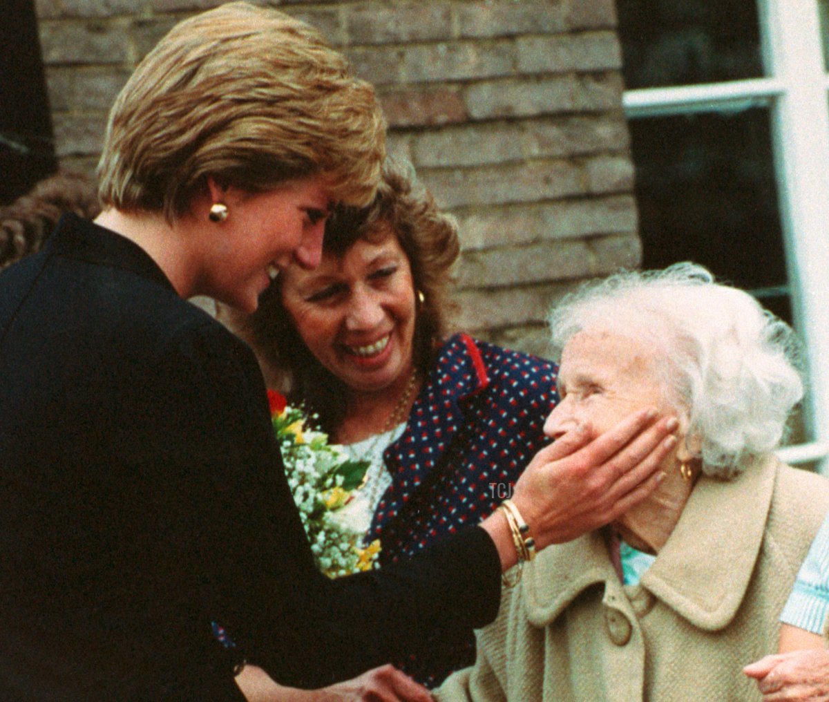 Diana, Princess of Wales at the Guinness Trust's Lord Gage Centre in Newham, London. She is seen touching the face of the centre's oldest resident Dolly Rowe, 18 Sep 1990