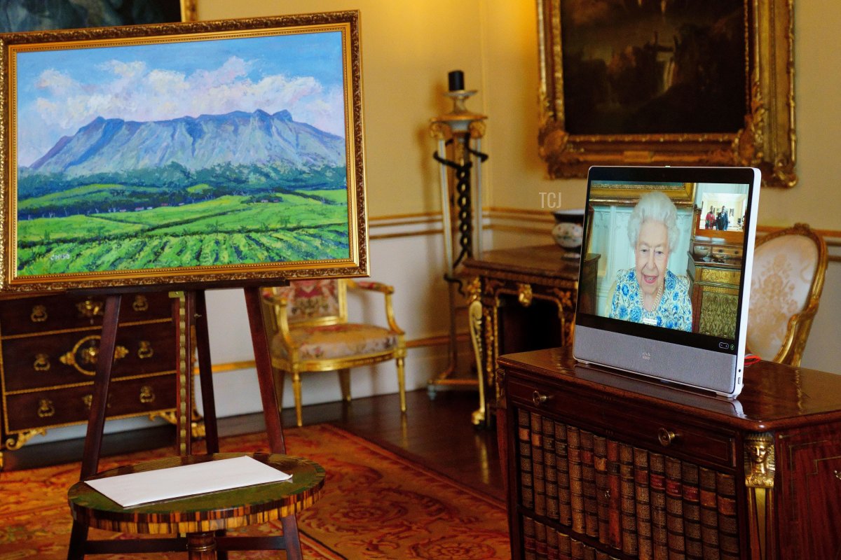 Queen Elizabeth II appears on a screen via videolink from Windsor Castle, where she is in residence, during a virtual audience to receive the High Commissioner of Malawi, Dr. Thomas Bisika (not pictured), who presented the painting on the left as a gift, at Buckingham Palace on March 3, 2022 in London, England