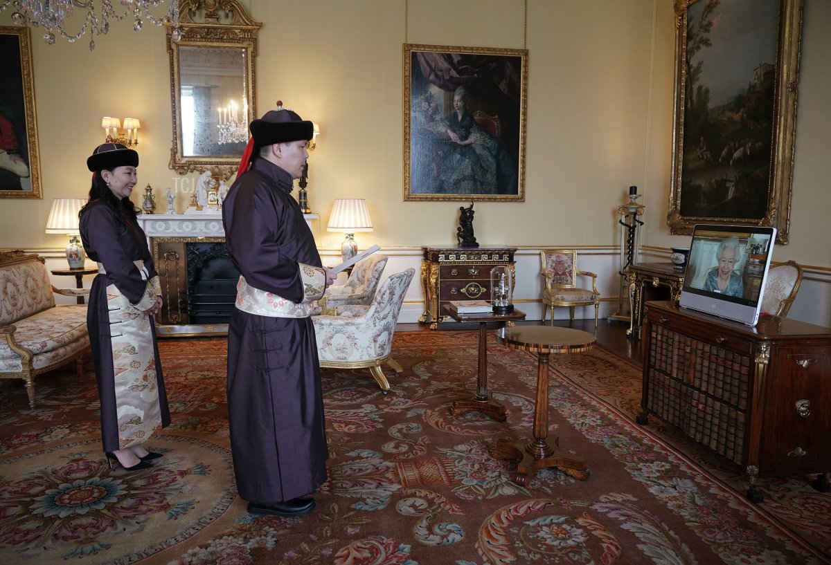 Queen Elizabeth II appears on a screen via videolink from Windsor Castle, where she is in residence, during a virtual audience to receive His Excellency Enkhsukh Battumur, Ambassador of Mongolia, and his wife Ganchimeg Purevdorj at Buckingham Palace on March 15, 2022 in London, England