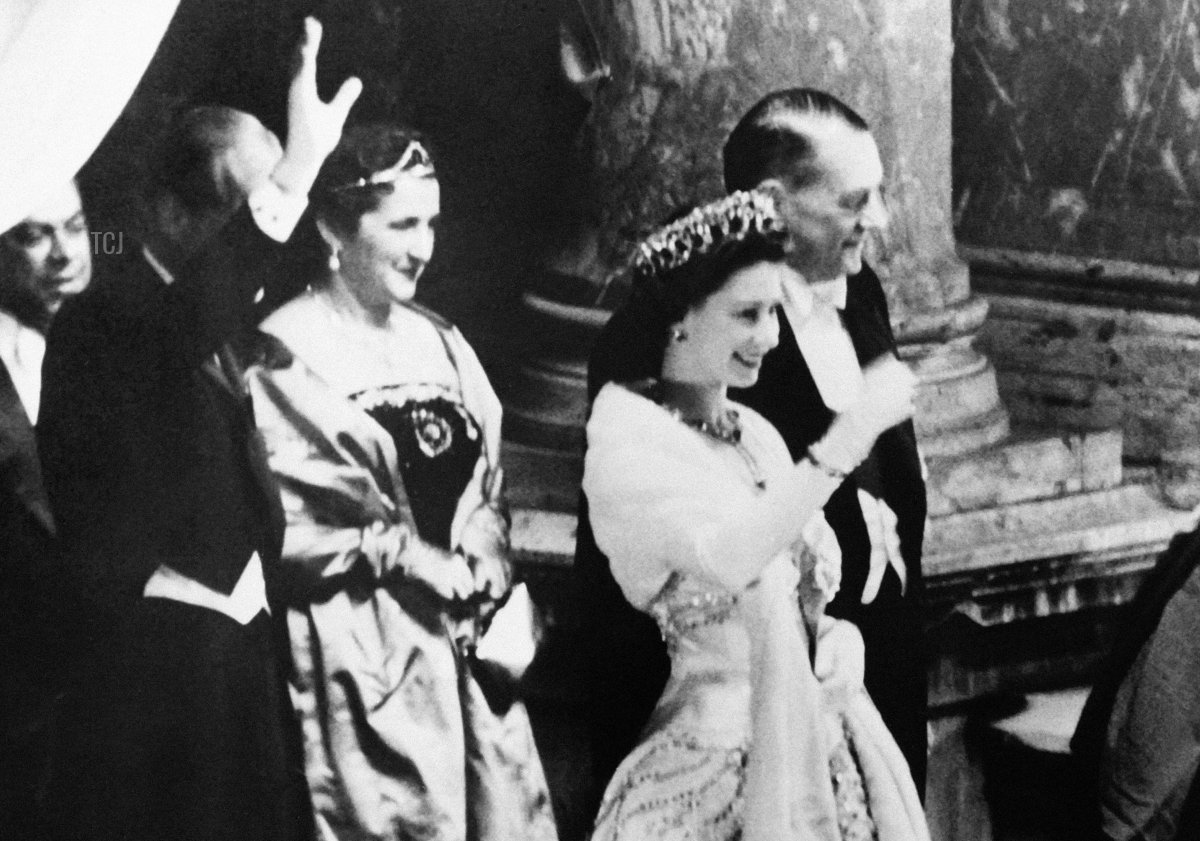 Queen Elizabeth II (R) and Duke of Edinburgh (L) flanked by French President Rene Coty and First lady Germaine Coty wave to the crowd from the balcony at the Opera Garnier in Paris during a state visit in France on April 9, 1957