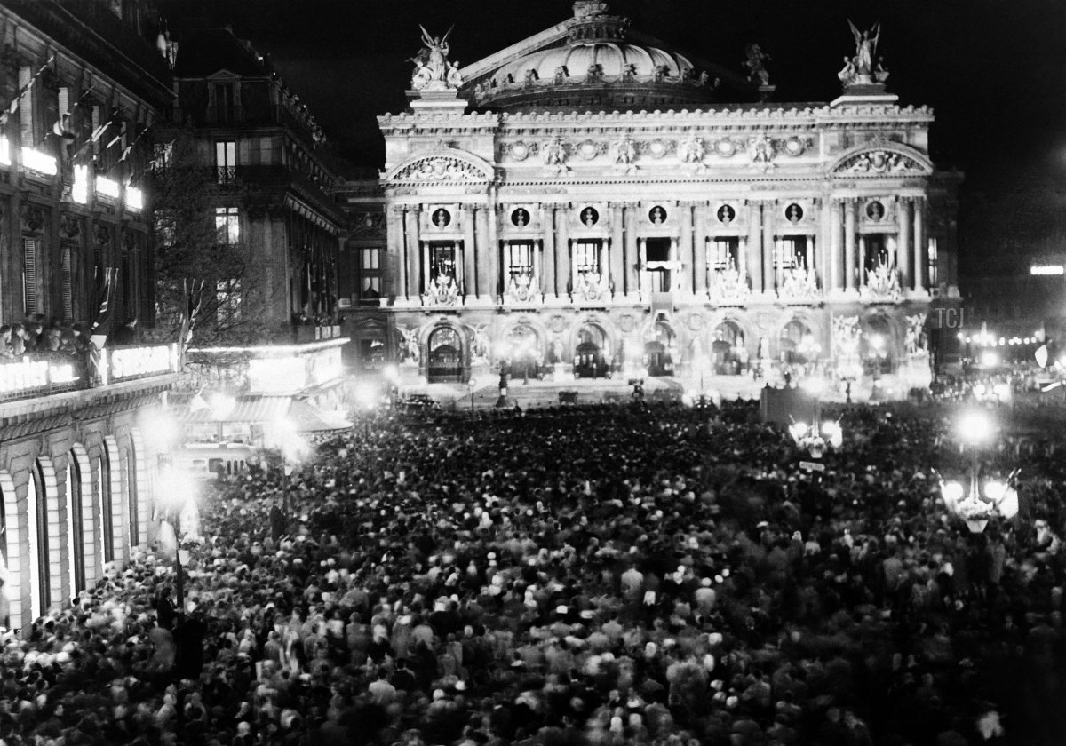 The crowd wait for the arrival of Queen Elizabeth II and Duke of Edinburgh at the balcony of the Opera Garnier in Paris during a state visit in France on April 9, 1957