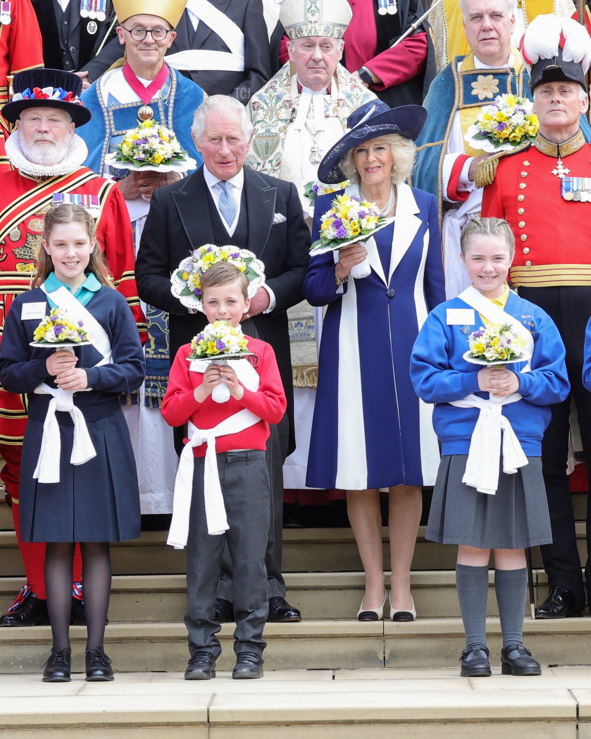 Prince Charles, Prince of Wales and Camilla, Duchess of Cornwall hold nosegays as they pose with the Queen's Bodyguard of the Yeomen of the Guard and guests as they attend the Royal Maundy Service at St George's Chapel on April 14, 2022 in Windsor, England