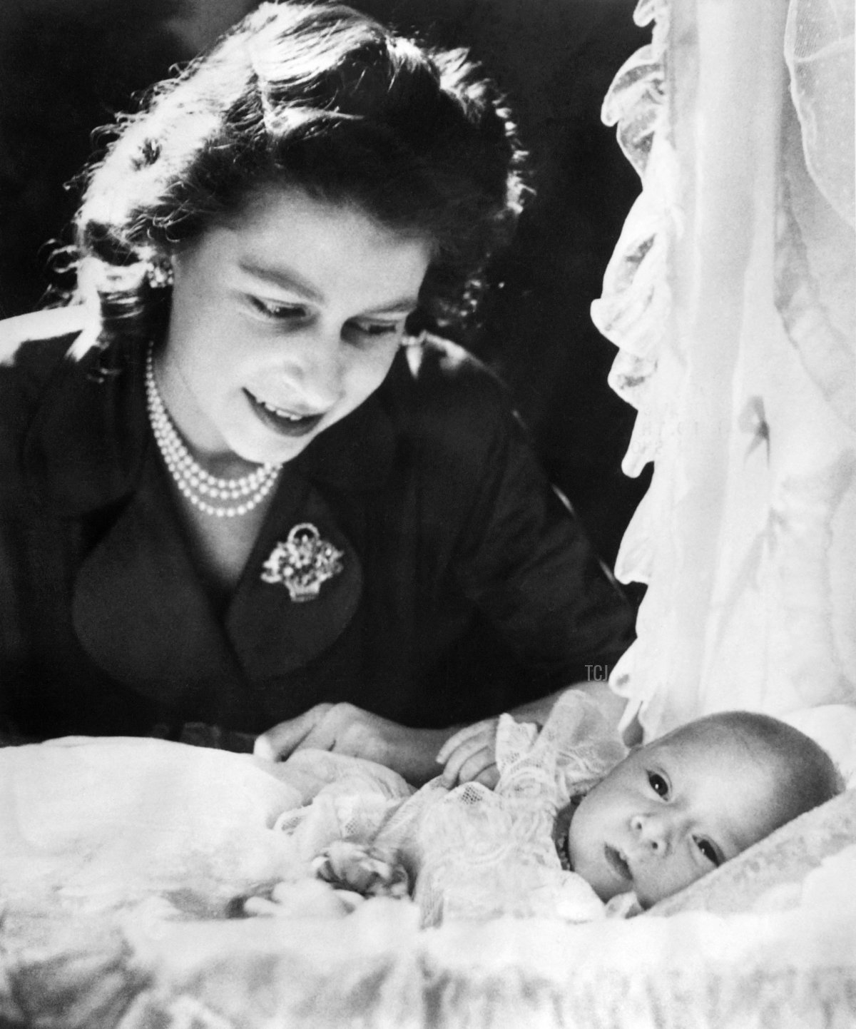 Britain's Princess Elizabeth bends over baby Prince Charles on January 1949