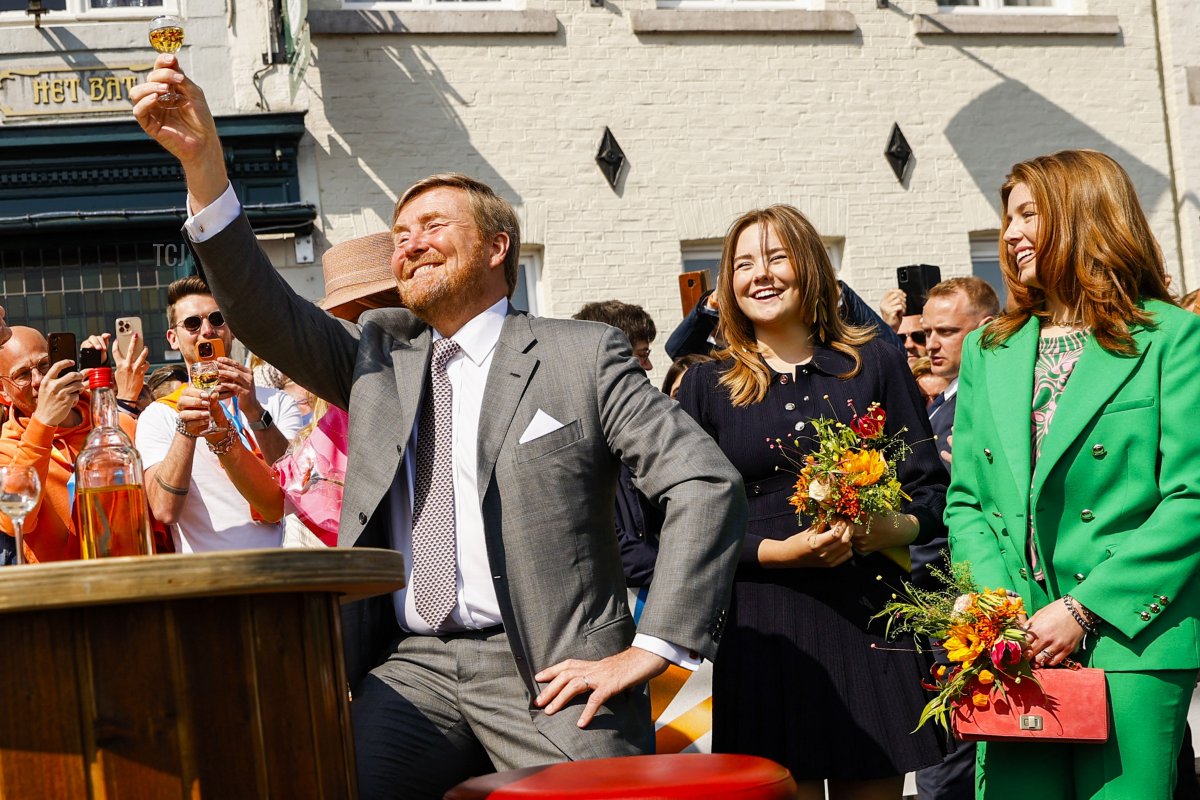 King Willem-Alexander of the Netherlands (L) toasts with an orange bitter flanked by Princess Ariane (2nd R) and Princess Alexia (R) during a gathering for King's Day in Maastricht, on April 27, 2022