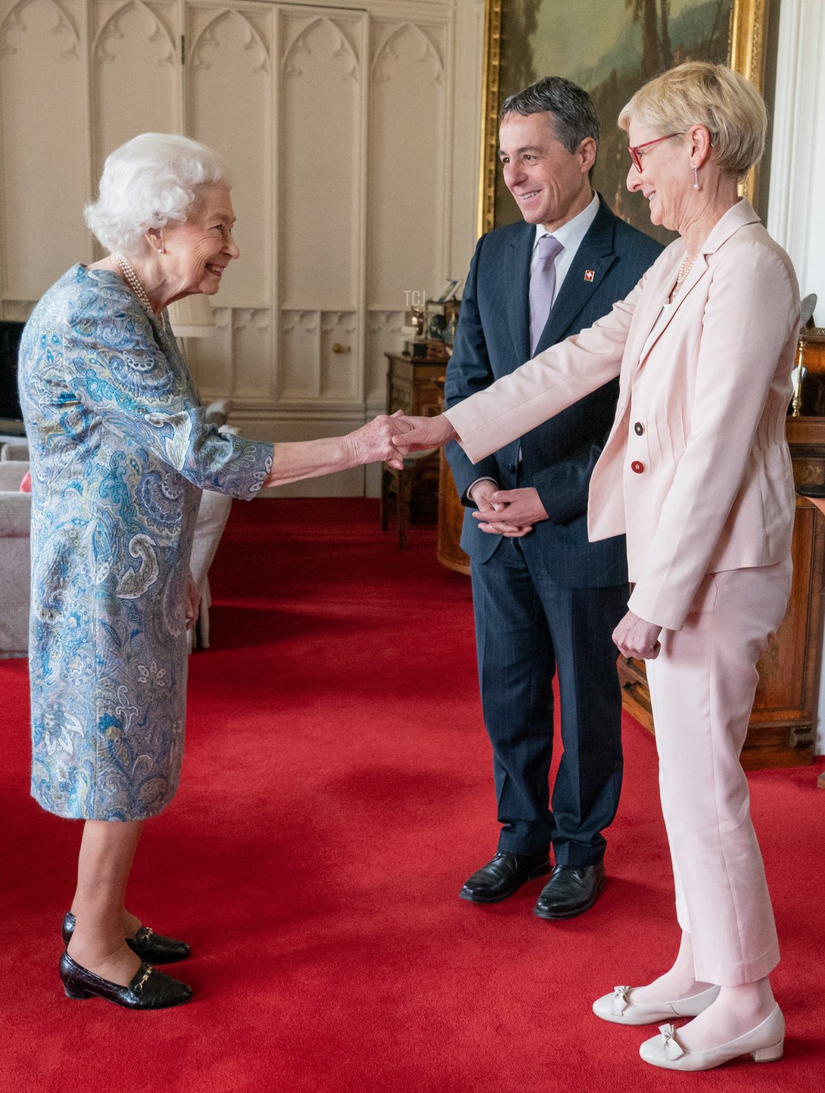 Britain's Queen Elizabeth II greets Switzerland's President Ignazio Cassis (C) and his wife Paola Cassis, during an audience at Windsor Castle, west of London on April 28, 2022