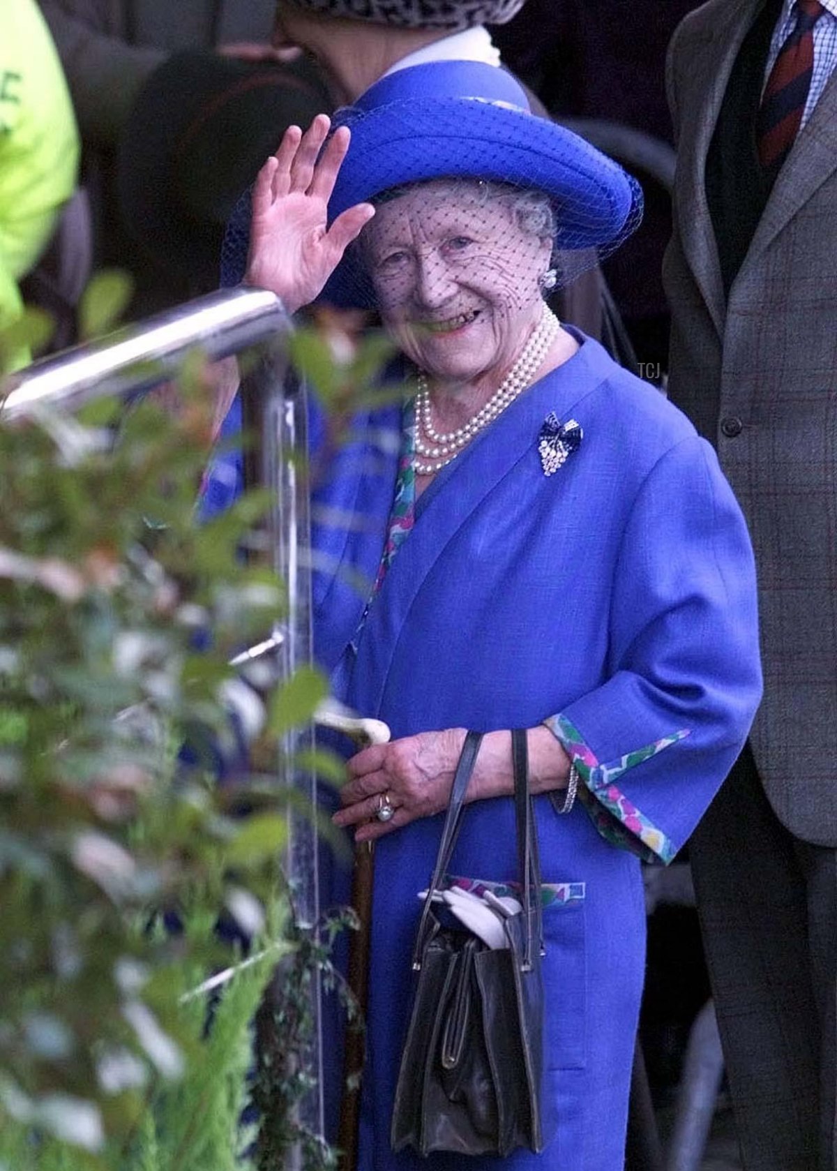 The Queen Mother waves to wellwishers as she arrives for the third and final day of the Cheltenham festival, 18 Mar 1999