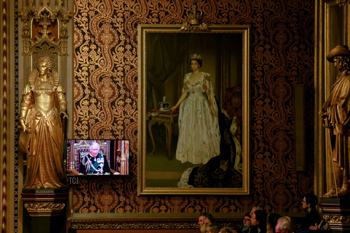 Britain's Prince Charles, Prince of Wales appears on a screen next to a painting of Queen Elizabeth at the Royal Gallery as he delivers the Queen's Speech during the State Opening of Parliament at the Houses of Parliament, in London, on May 10, 2022