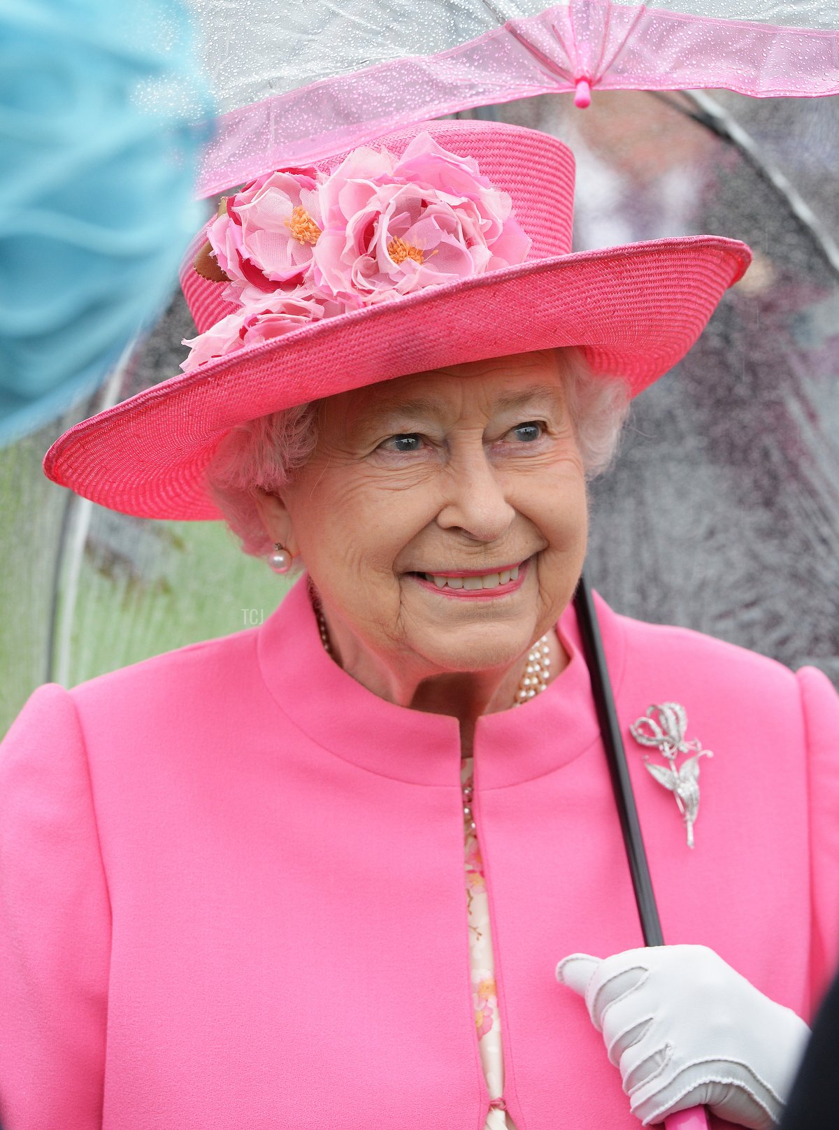 Queen Elizabeth II shelters from the rain under an umbrella during the first Royal Garden Party of the year in the grounds of Buckingham Palace on May 10, 2016 in London, England