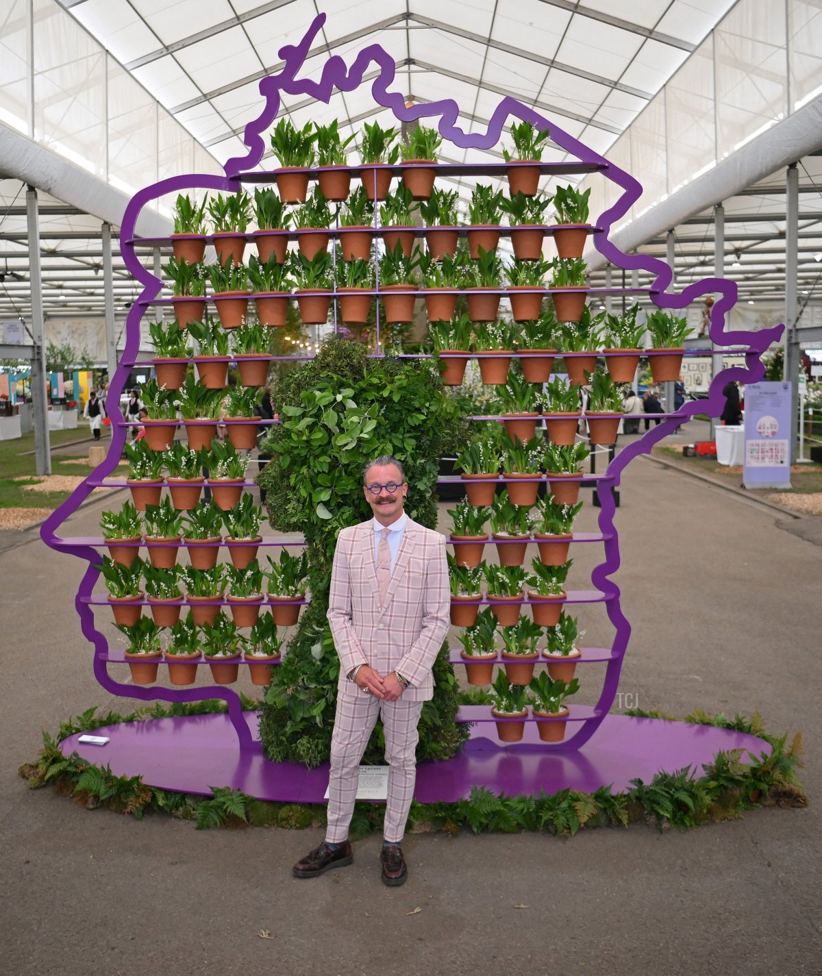 Florist Simon Lycett poses with a display he created in honour of Britain's Queen Elizabeth II, featuring 70 hand-thrown pots - one for every year of the Queen's reign -- is during the 2022 RHS Chelsea Flower Show in London on May 23, 2022