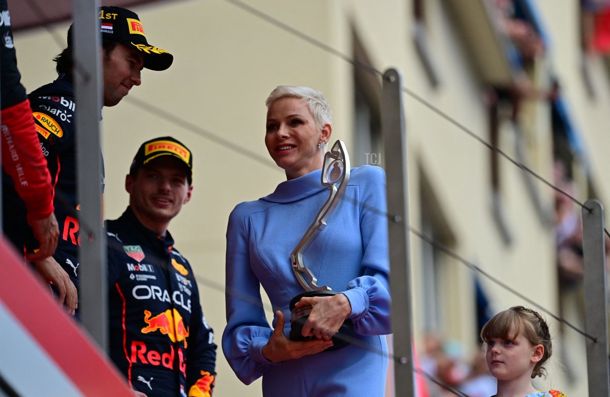 Winner Red Bull Racing's Mexican driver Sergio Perez (L) receives the winner's trophy from Princess Charlene of Monaco (C) on the podium after the Monaco Formula 1 Grand Prix at the Monaco street circuit in Monaco, on May 29, 2022