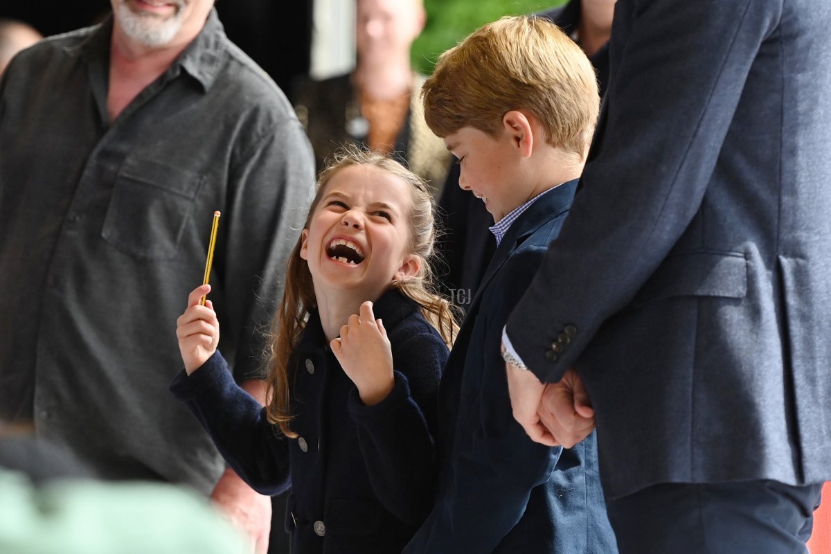 Princess Charlotte of Cambridge laughs as she conducts a band next to her brother Prince George of Cambridge during a visit to Cardiff Castle on June 04, 2022 in Cardiff, Wales