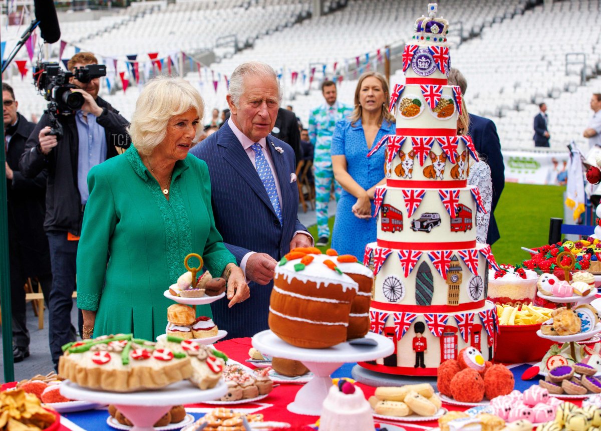 Britain's Prince Charles, Prince of Wales, and Britain's Camilla, Duchess of Cornwall, admire a felt art piece by Lucy Sparrow, featuring the Platinum Pudding, scotch eggs and fruit platters as they attend the Big Jubilee Lunch at the Oval in London on June 5, 2022 as part of Queen Elizabeth II's platinum jubilee celebrations