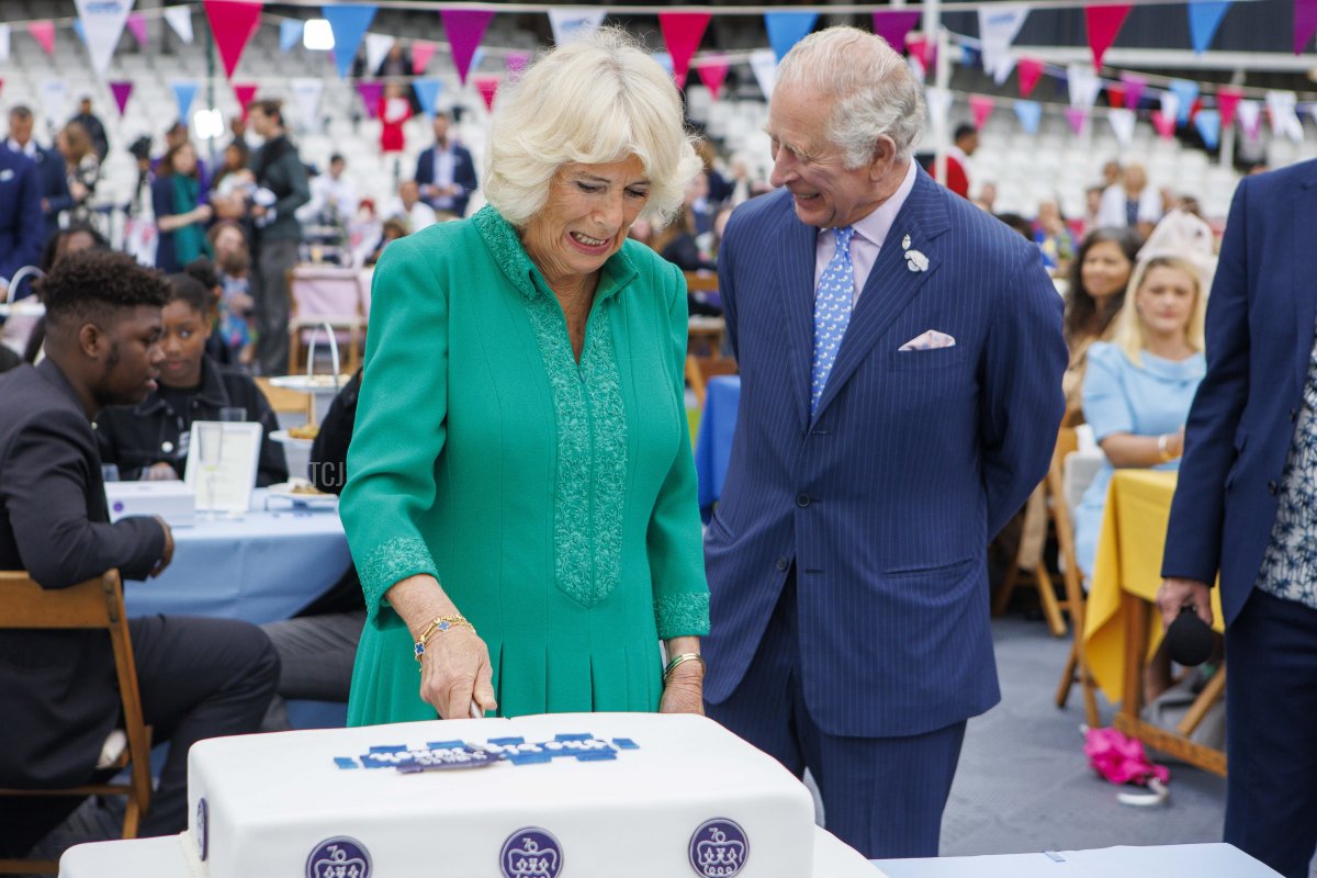 Prince Charles, Prince Of Wales, and Camilla, Duchess of Cornwall, cut a cake during a Big Jubilee Lunch at The Oval on June 5, 2022 in London, England