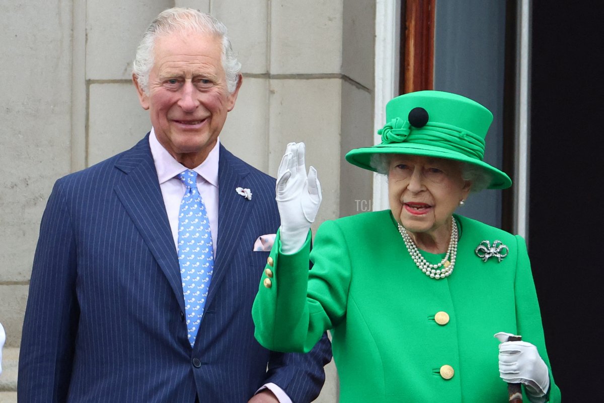 Britain's Queen Elizabeth II stands beside Britain's Prince Charles, Prince of Wales and waves to the public as she appears on Buckingham Palace balcony at the end of the Platinum Pageant in London on June 5, 2022 as part of Queen Elizabeth II's platinum jubilee celebrations
