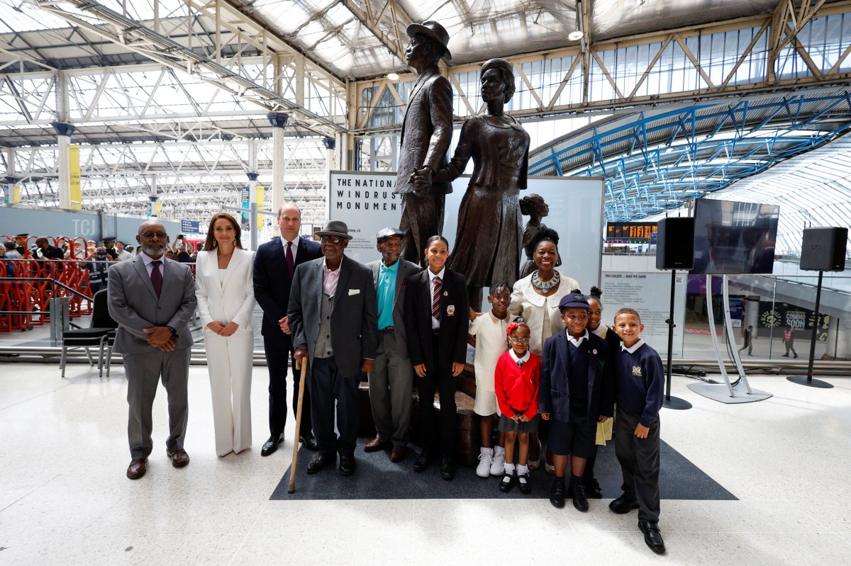 Prince William and Catherine, Duchess of Cambridge accompanied by Baroness Floella Benjamin, Windrush passengers Alford Gardner and John Richards and children pose for a picture next to the National Windrush Monument at Waterloo Station on June 22, 2022 in London, England