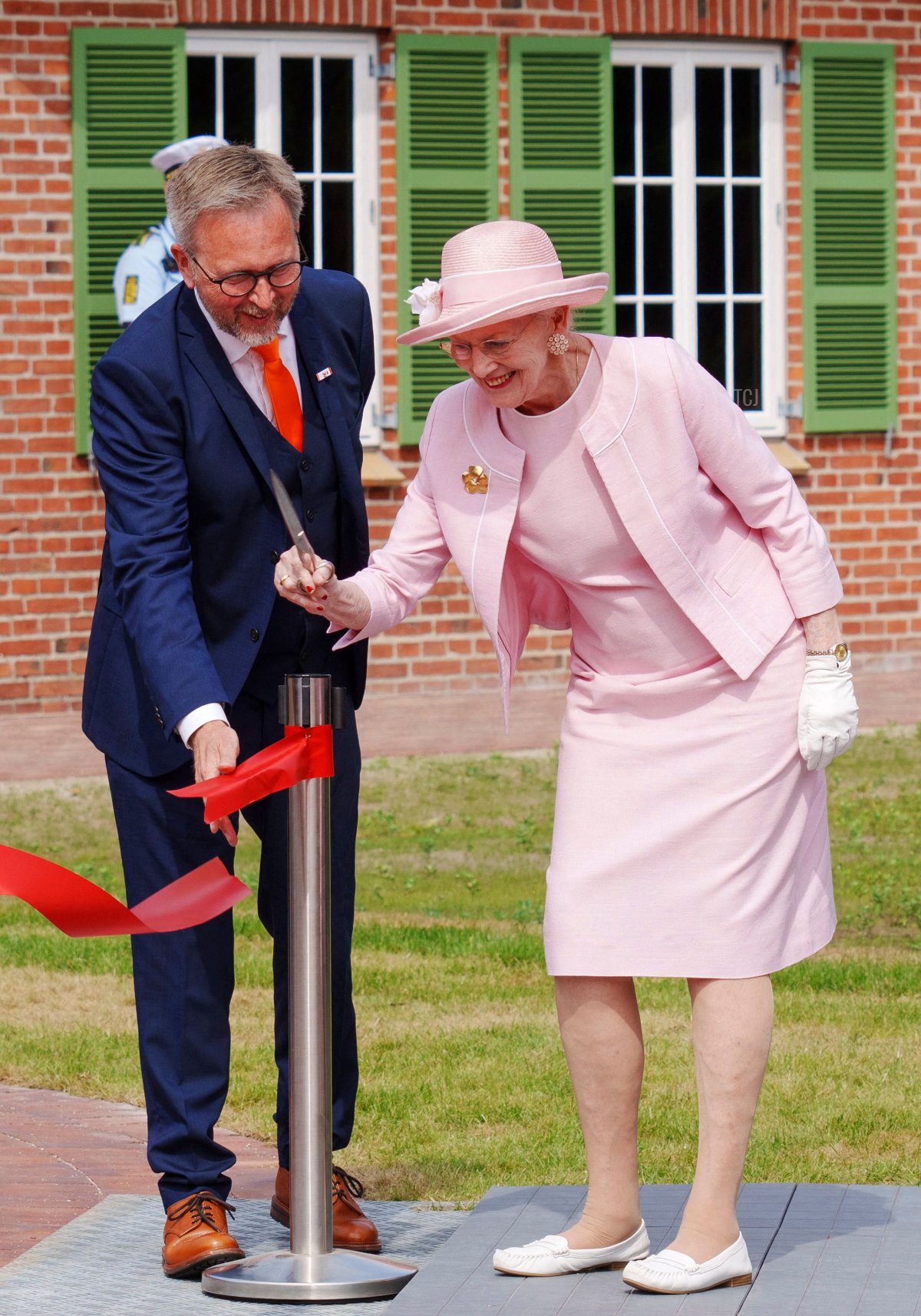 Danish Queen Margrethe cuts the ribbon next to museum director Claus Kjeld Jensen to inaugurate the new Danish refugee museum FLUGT (escape) in Oksboel, Denmark, on June 25, 2022