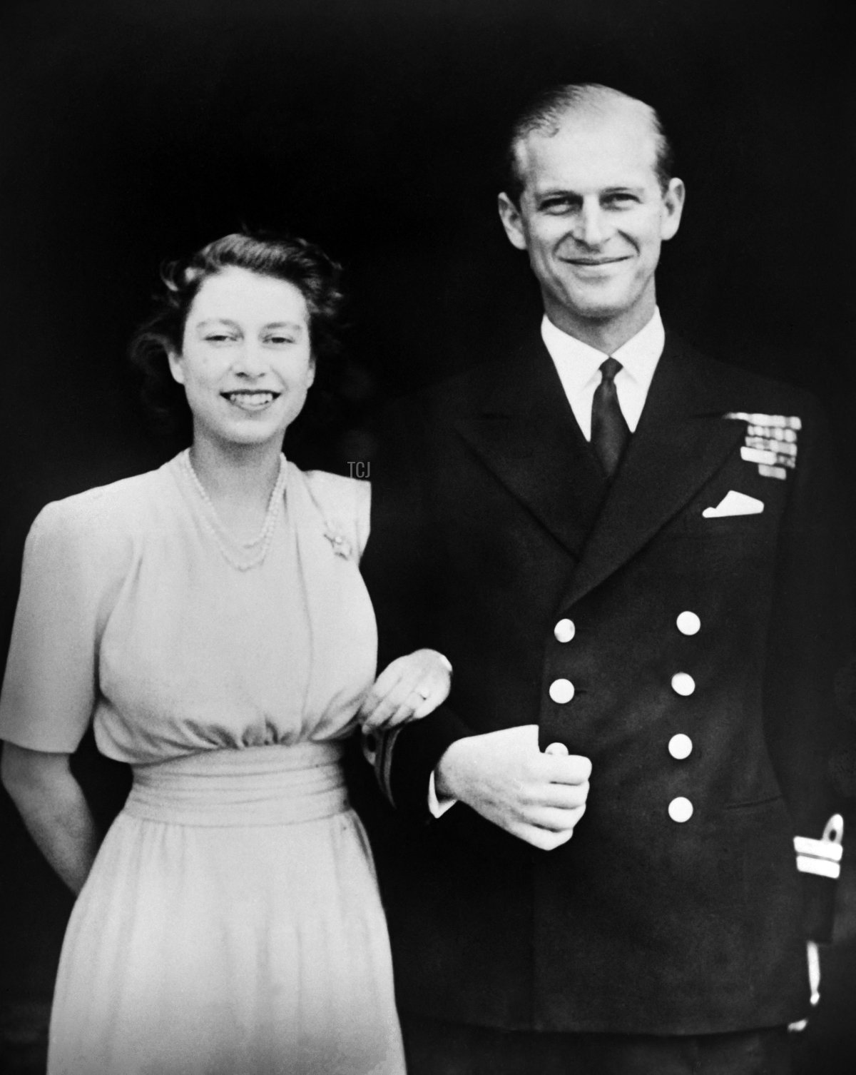 Princess Elizabeth and Prince Philip of Greece pose on the day of their engagement, in July 1947, outside Buckingham Palace in London