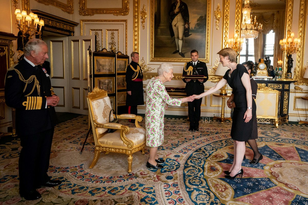 Britain's Prince Charles, Prince of Wales (L) watches as Britain's Queen Elizabeth II (C) presents the George Cross to NHS England CEO Amanda Pritchard (2R), and May Parsons, Modern Matron at University Hospital Coventry and Warkwickshire, representatives of Britain's National Health Service (NHS), during an Audience at Windsor Castle, west of London on July 12, 2022