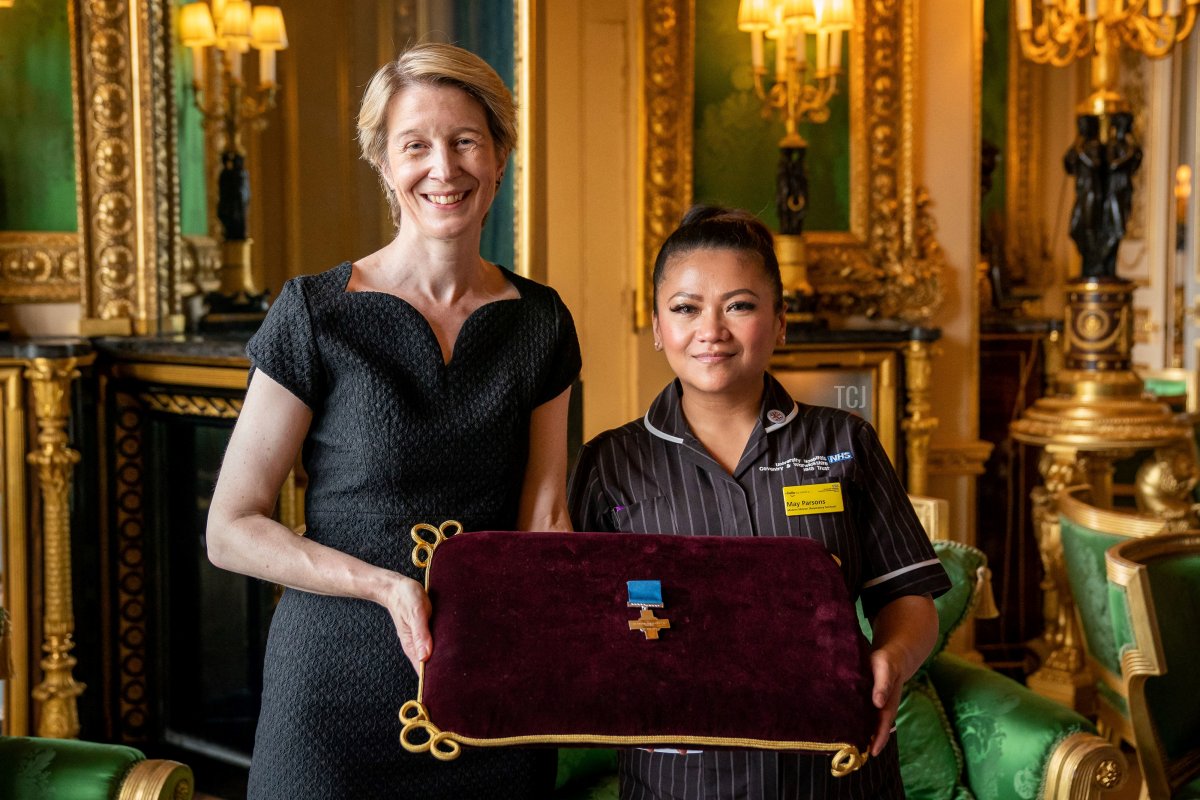 NHS England CEO Amanda Pritchard (L), and May Parsons, Modern Matron at University Hospital Coventry and Warkwickshire, representatives of Britain's National Health Service (NHS), pose with a George Cross medal awarded to NHS England during an Audience at Windsor Castle, west of London on July 12, 2022