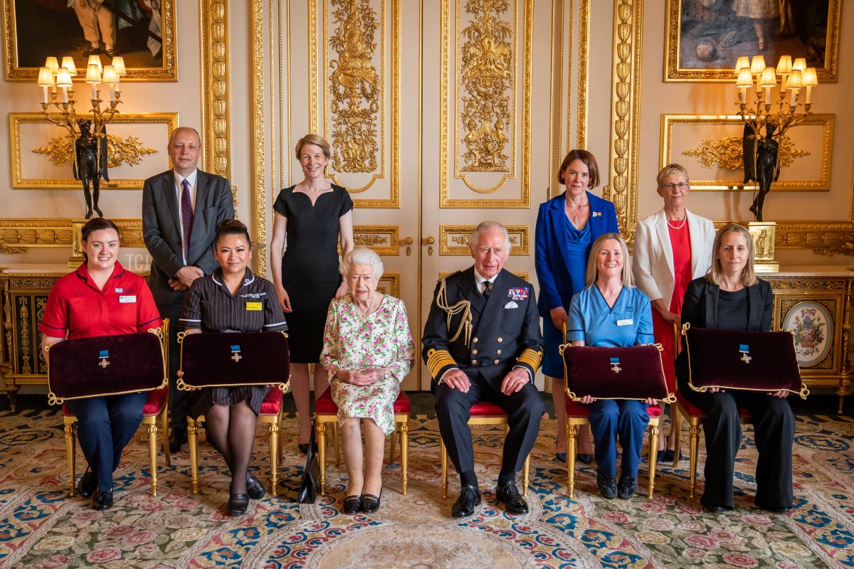 Queen Elizabeth II presents the George Cross to representatives of the National Health Service Mr Peter May, Permanent Secretary at the Department of Health and Chief Executive of Health and Social care, and Sister Joanna Hogg, Royal Victoria Hospital Emergency Department, during an Audience at Windsor Castle on July 12, 2022 in Windsor, England