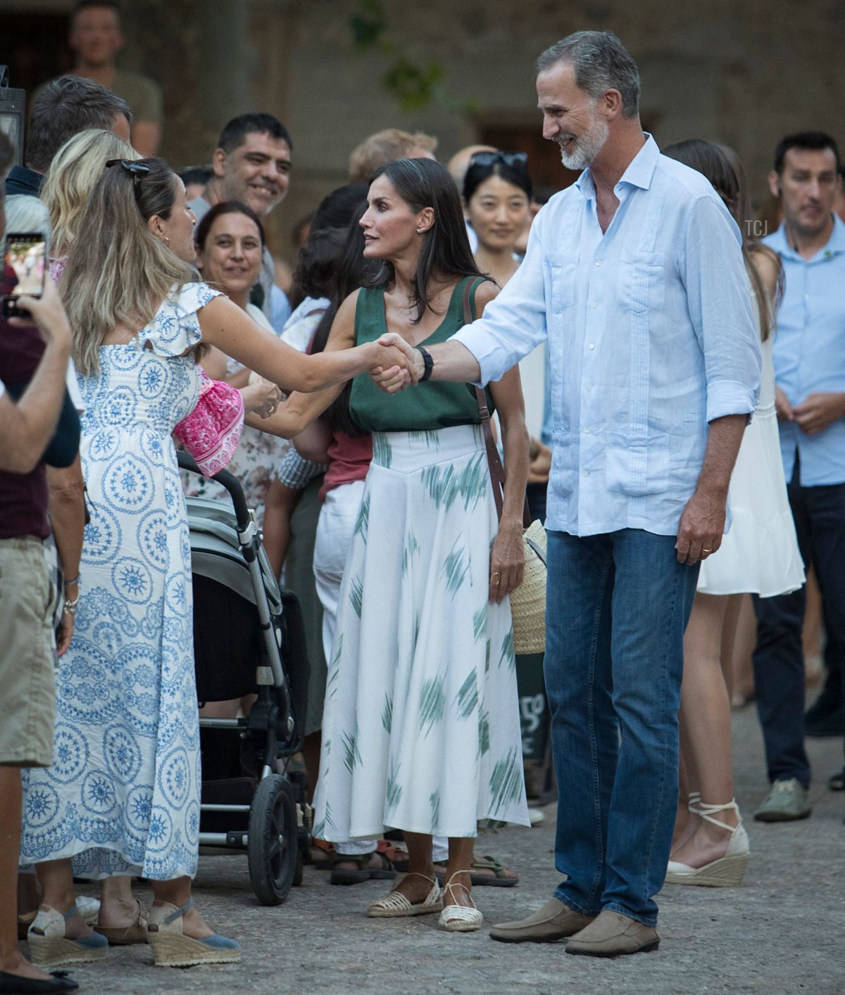 Spain's Queen Letizia (C) and Spain's King Felipe VI (R) shake hands with people during a visit of the Cartoixa of Valldemossa on the island of Mallorca during their summer holidays in the Balearic islands on August 1, 2022
