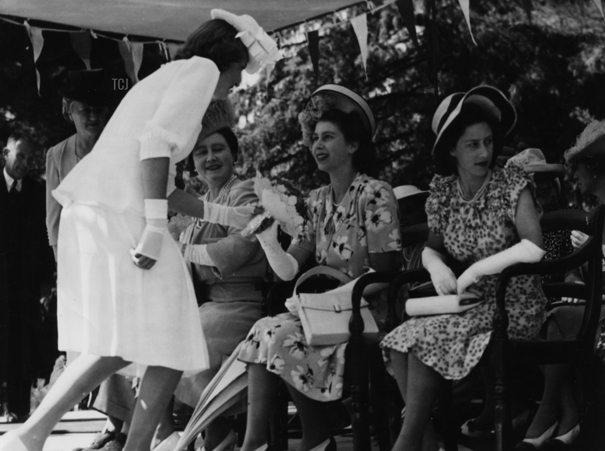 Rene du Preez, daughter of the Mayor of Ladybrand, presenting Princess Elizabeth with a bunch of flowers, seated with her mother Queen Elizabeth and sister Princess Margaret (right), in the Orange Free State, March 19th 1947